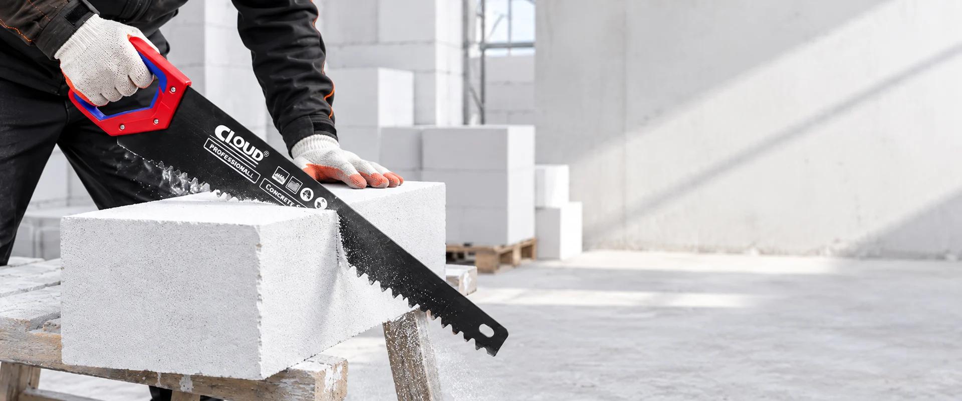 Construction hand saw cutting a masonry block on a workbench
